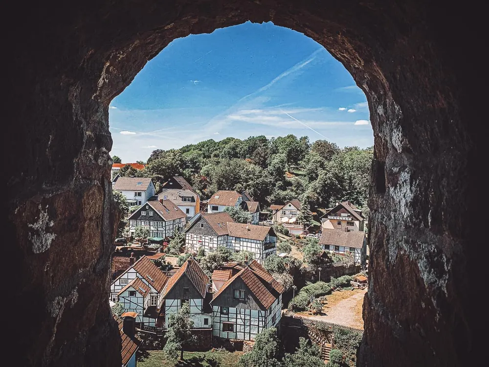Blick durch eine Öffnung in der Burgmauer auf die Fachwerkhäuser der Altstadt